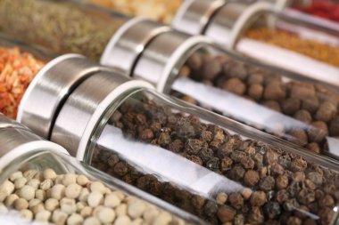 Arka plan olarak cam kavanozlardaki farklı baharatlar, yakın plan