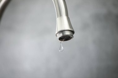 Su kavramını sakla. Gri arkaplandan damlayan su, yakın plan