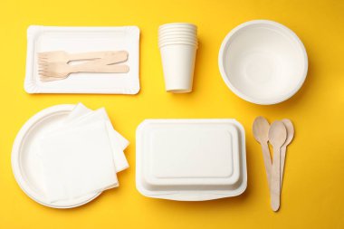 Sarı arkaplanda tek kullanımlık sofra takımı, düz konum