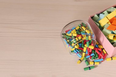 Açık ahşap masa üzerindeki renkli kağıt parçaları, manzaranın üstünde. Metin için boşluk