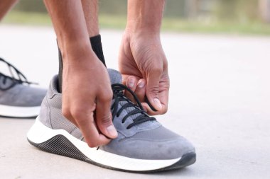 Koşucu ayakkabısının bağcığını dışarıda bağlıyor, yakın plan. Metin için boşluk