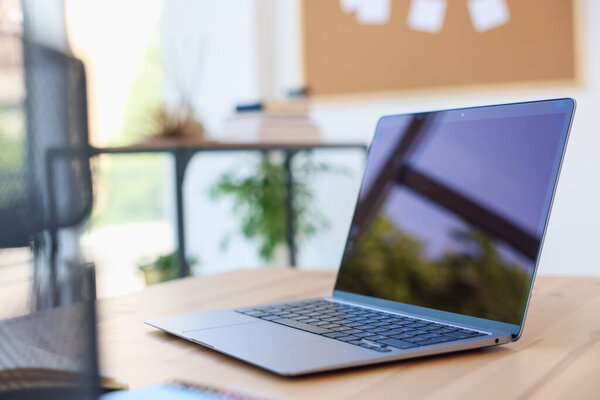 Рабочее место. Современный ноутбук на деревянном столе в помещении, крупный план