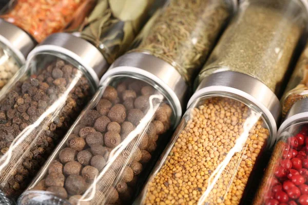 Arka plan olarak cam kavanozlardaki farklı baharatlar, yakın plan