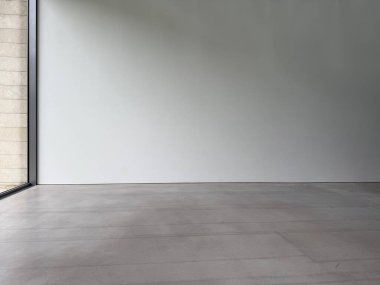 Beyaz duvarı ve gri zemini olan boş bir oda.