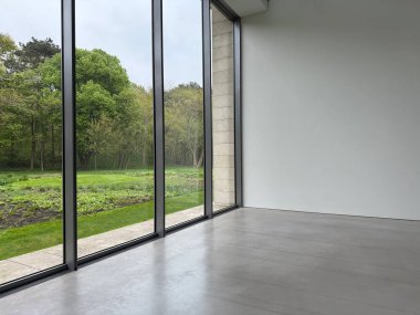 Panoramik pencereli ve gri zeminli boş oda