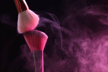 Siyah arka planda pembe göz farlı makyaj fırçaları, yakın plan. Metin için boşluk