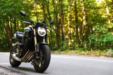 Modern siyah motosiklet açık yolda park edilmiş. Metin için boşluk