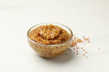 Beyaz mermer masada, kasede tam tahıllı hardal, yakın plan.