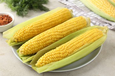 Lezzetli haşlanmış mısır koçanları ışık masasında, yakın plan.