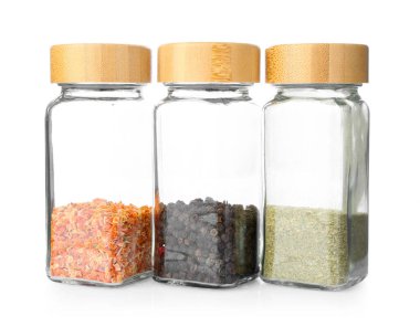 Beyaza izole edilmiş cam kavanozlardaki Aromatik baharatlar