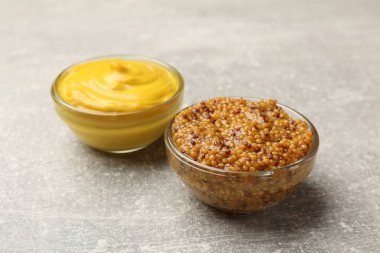 Açık gri masada farklı hardal türleri, yakın plan.