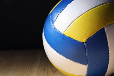 Tahta zeminde bir voleybol topu siyah arka plana karşı, yakın plan. Metin için boşluk
