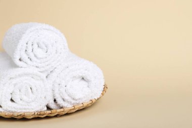 Bej arka planda rulo havlular, yakın plan. Metin için boşluk