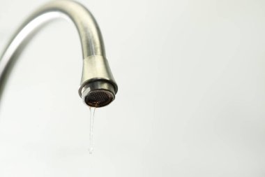 Su kavramını sakla. Arka plandaki musluktan su damlıyor, yakın plan. Metin için boşluk