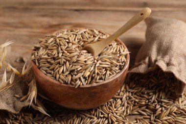 Yulaf taneleri, çiviler, kase ve çuvallar ahşap masada, yakın plan.