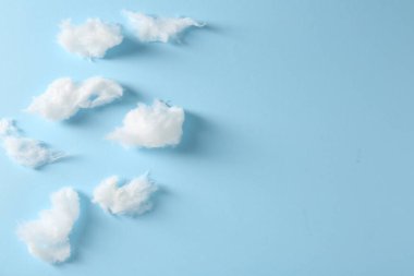 Açık mavi arka planda, bembeyaz pamuk şekerden yapılmış bulutlar düz yerde. Metin için boşluk