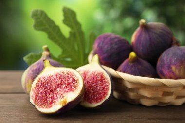 Taze incir ve yeşil yaprak dışarıda, ahşap masada, yakın plan.