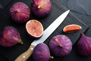 Taze incir ve bıçak siyah desenli masa, üst manzara.