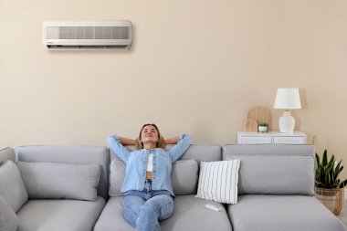 Klimalı kanepede rahat bir sıcaklığın tadını çıkaran bir kadın.