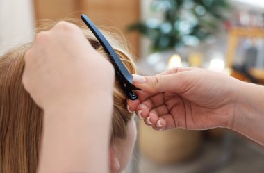 Profesyonel kuaför müşteriyle kuaförde çalışıyor.