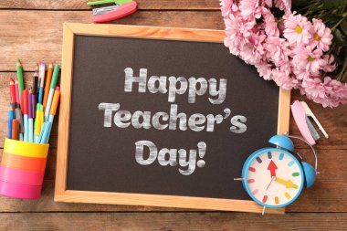 Küçük tahta üzerinde çiçekler ve metinlerle Öğretmenler Günü tebrik kartın kutlu olsun.