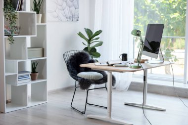 Ev çalışma alanı. Modern bilgisayar, ev bitkisi ve kırtasiye malzemesi ahşap masa içinde.