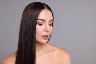 Açık gri arkaplanda katman prosedüründen sonra güzel pürüzsüz saçlı kadın, metin için boşluk