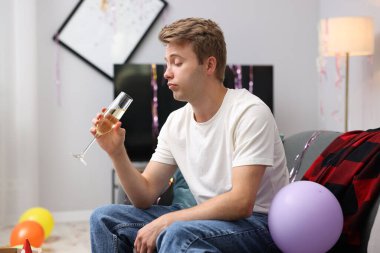 Bir bardak alkollü adam partiden sonra dağınık bir odada kanepede akşamdan kalma.