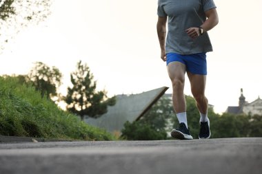 Spor giyimli atletik genç adam dışarı koşuyor, yakın plan. Metin için boşluk