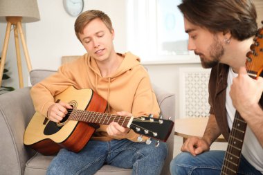 Öğretmenim evde gitar çalmayı öğretiyor.