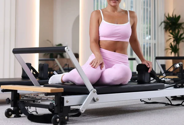 Pilates stüdyosunda yenilikçi bir kadın oturuyor.
