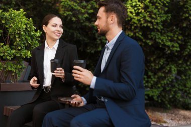 Paket kahve. Dışarıdaki bankta kağıt bardak içen iş adamları.