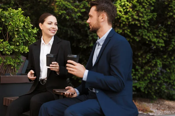 Paket kahve. Dışarıdaki bankta kağıt bardak içen iş adamları.