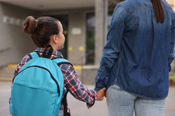 Anne kızını açık hava okuluna götürüyor.