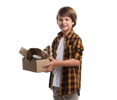 Geri dönüşüm. Beyaz arka planda farklı atık kağıtlarıyla dolu karton kutusu olan sevimli küçük çocuk.