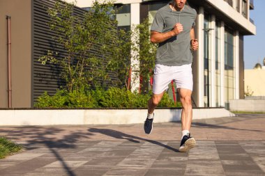 Kulaklıklı bir adam güneşli bir günde dışarı koşuyor, kapanıyor. Metin için boşluk