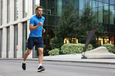 Spor giyimli bir adam açık havada koşuyor, mesaj için yer var.