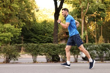 Spor giyimli bir adam açık havada koşuyor, mesaj için yer var.