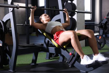 Spor salonunda halterli kadın eğitimi.