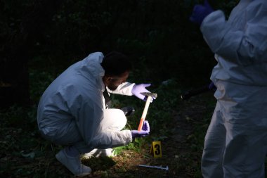 Adli tıp uzmanları dışarıdaki suç mahallinde çalışıyor.