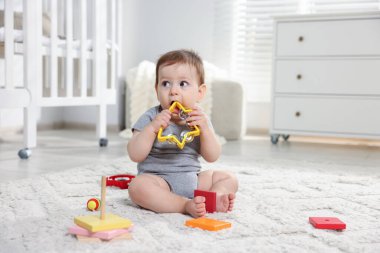 Odada oyuncaklarla oynayan şirin bir bebek.