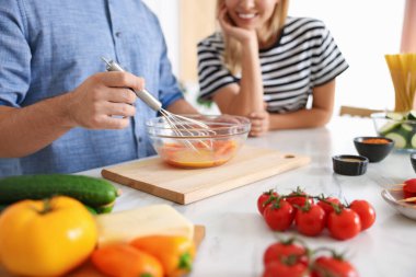 Çift içeride yemek pişiriyor, yakın plan.