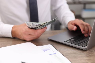 Ahşap masada dolar sayan adam, yakın plan.