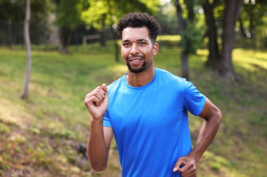 Portrait of smiling man running in park