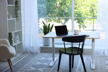 Ev çalışma alanı. Modern laptop ve kırtasiye malzemeleri ahşap masa içinde.