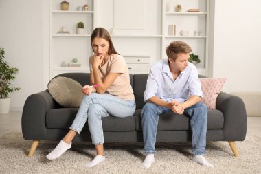 Evdeki koltukta hamilelik testi olan endişeli çift.