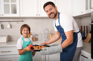 Baba ve oğul mutfakta hamur işi pişiriyor.