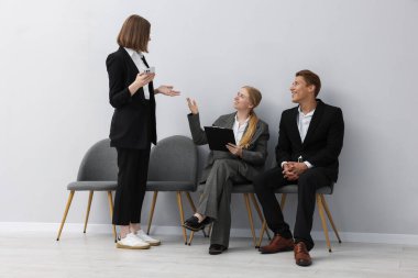 İnsanlar içeride sandalyede kuyrukta bekliyorlar.