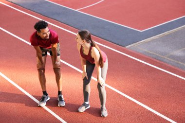 Stadyumda koştuktan sonra dinlenen gülümseyen çift. Metin için boşluk