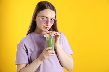 Turuncu arka planda samandan ferahlatıcı içecek içen kadın, mesaj için yer